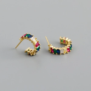 Detail of C-shaped gold earrings with rainbow baguette-cut colorful zircon gemstones