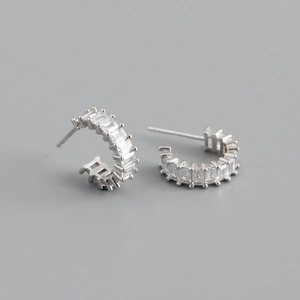 Macro shot of S925 sterling silver C-shaped earrings with square cubic zirconia inlay