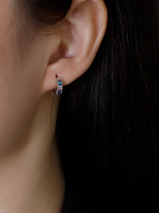 Close-up of S925 sterling silver huggie earrings featuring multicolored baguette zircons