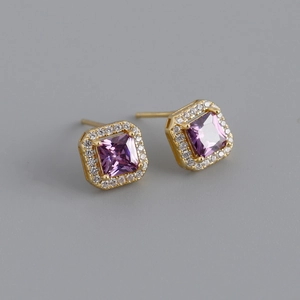 Macro shot of gold square stud earrings with purple zircon and white diamond halo