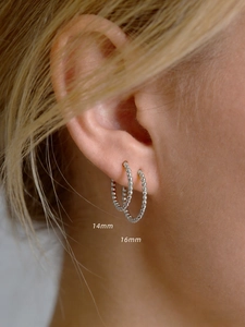 Detail of 14mm and 16mm S925 sterling silver beaded hoop earrings worn on model