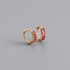 Macro shot of 925 silver gold-plated hoop earrings with rectangular pink zircon stones