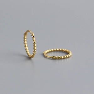 Detail of gold beaded hoop earrings featuring a minimalist textured dot design in S925 silver