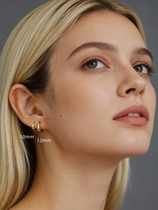 Close-up of 10mm and 12mm polished gold 925 sterling silver hoop earrings worn on ear