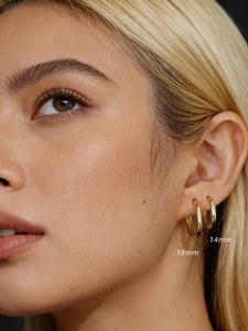 Detailed close-up of 14mm and 18mm gold plated sterling silver hoop earrings on model