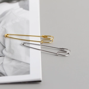 Detail van luxe s925 zilveren veiligheidsspeld oorbellen in goud en zilveren afwerking
