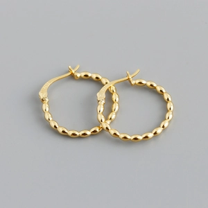 Macro detail of gold S925 sterling silver hoop earrings with textured beaded edge design