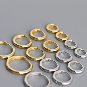 Macro view of sterling silver hoop earrings in gold and silver finish with snap closure