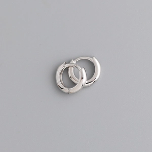 Detailed close-up of chunky polished silver hoop earrings with a secure clasp design