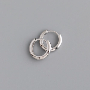 Macro detail of polished 925 sterling silver hoop earrings with secure snap closure