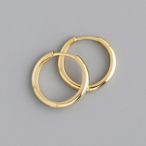 Macro shot of minimalist gold hoop earrings featuring a polished 925 sterling silver finish