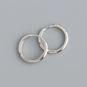 Close-up of polished silver hoop earrings with secure click-top closure on grey background