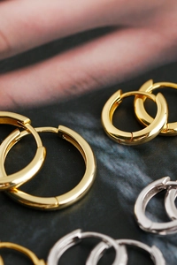 Macro close-up of minimalist gold and silver 925 sterling silver hoop earrings