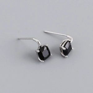 Macro shot of silver stud earrings featuring black square-cut cubic zirconia in prong setting
