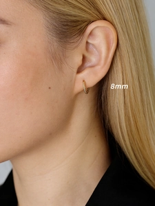 Vue macro de créoles torsadées dorées de 8mm montrant le style et la taille portées