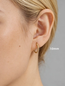 Gros plan d'une boucle d'oreille créole torsadée dorée de 10mm avec texture spirale