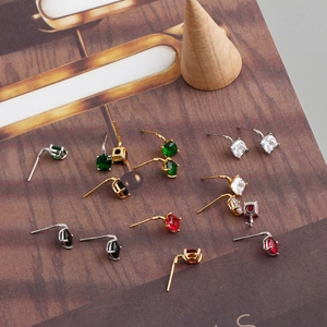 Detail of colorful zircon stud earrings with various cuts on a vintage book background