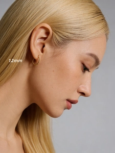 Gros plan de créoles torsadées de 12mm plaquées or portées par un mannequin femme