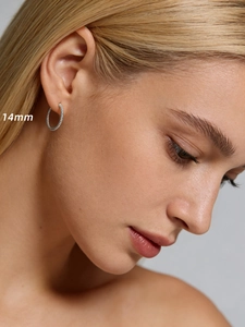 Gros plan de créoles torsadées en argent de 14mm montrant la texture sur un mannequin