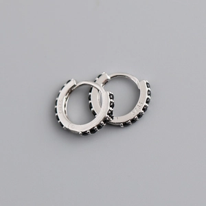 Gros plan de créoles en argent sterling S925 serties de zircons cubiques noirs fins