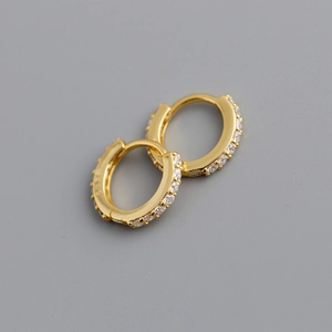Gros plan de boucles d'oreilles en argent 925 doré avec zircons blancs et poinçon S925