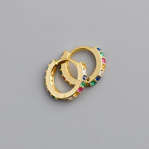 Détail de boucles d'oreilles huggie en argent S925 doré avec zircons colorés incrustés