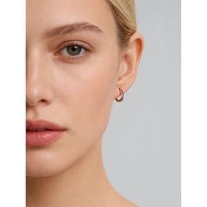 Créoles en argent S925 doré serties de zircons roses portées sur l'oreille