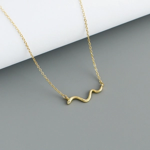 Detailaufnahme der goldenen Schlangenkette mit feiner Schuppentextur und edlem Glanz