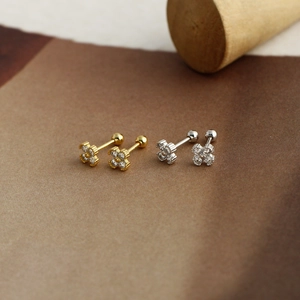 Macro shot of silver and gold S925 floral stud earrings with round zircons and screw backs