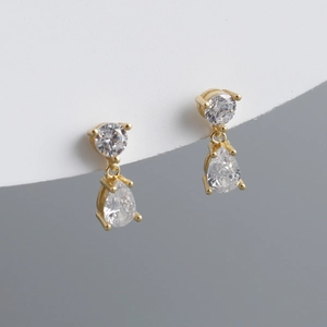 Macro view of gold-plated pear-cut cubic zirconia drop earrings with claw setting