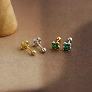 Macro view of clover stud earrings with green heart stones and secure screw ball backs
