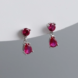 Detail showing S925 silver earrings with pear-shaped red zircon and round accent stones