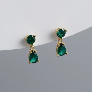 Close-up of teardrop green zircon gold earrings with classic four-prong setting