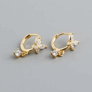Macro shot of gold butterfly huggie earrings with sparkling clear zircon stones