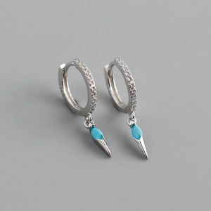 Detail of silver hoop earrings with turquoise stones and cone pendants in close-up view