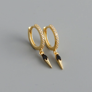 Detailed macro view of gold hoop earrings with black marquise stone and zircon pavé