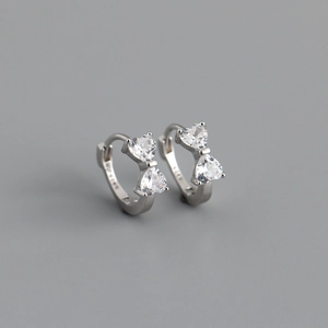 Détail de boucles d'oreilles en argent S925 avec zircons étincelants en forme de nœud