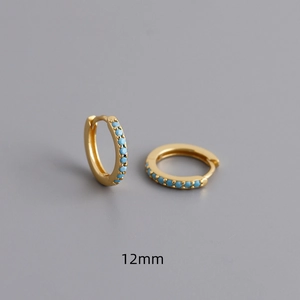 Details van 12 mm gouden oorringen met turquoise zirkonia steentjes op grijze achtergrond