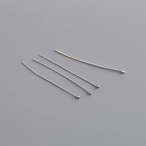 Gros plan de quatre tiges à tête ronde en argent poli pour la création de bijoux