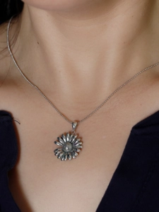 Dettaglio di una collana con ciondolo a margherita in argento S925 vintage