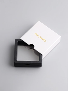 Detail van witte vierkante PE-folie sieradendoos met gouden Fine Jewelry tekst