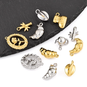 Detailed macro view of gold and silver rose and bamboo pendants on a slate block