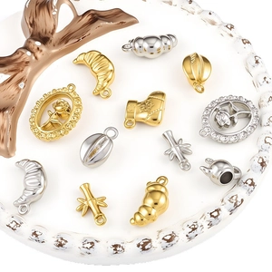 Various stainless steel gold and silver pendants for DIY jewelry making on white tray