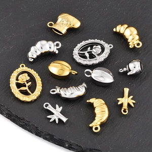 Macro shot of assorted gold and silver stainless steel pendants with rose and croissant motifs