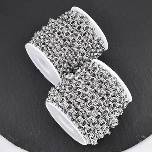 Macro-opname van hoogwaardige roestvrijstalen dubbele ringketting op een witte spoel