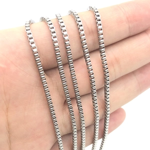 Polished silver stainless steel box chain necklace held in hand for scale and detail