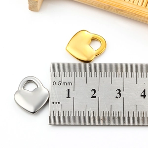 Detalle macro del colgante de corazón de 15 mm en oro y plata con escala de medida
