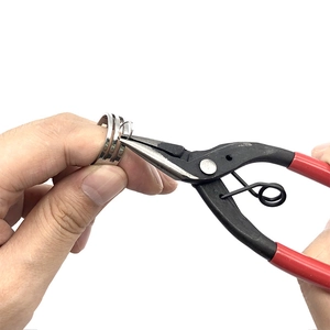 Polished stainless steel ring opening tool being used with professional jewelry pliers
