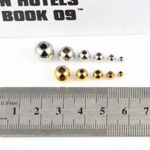 Polierte Gold- und Silber-Edelstahlperlen mit Lineal zur Größenreferenz dargestellt