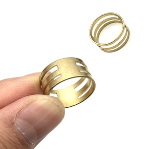 Detailansicht von zwei vergoldeten Messingringen mit modernem hohlem dreireihigem Design